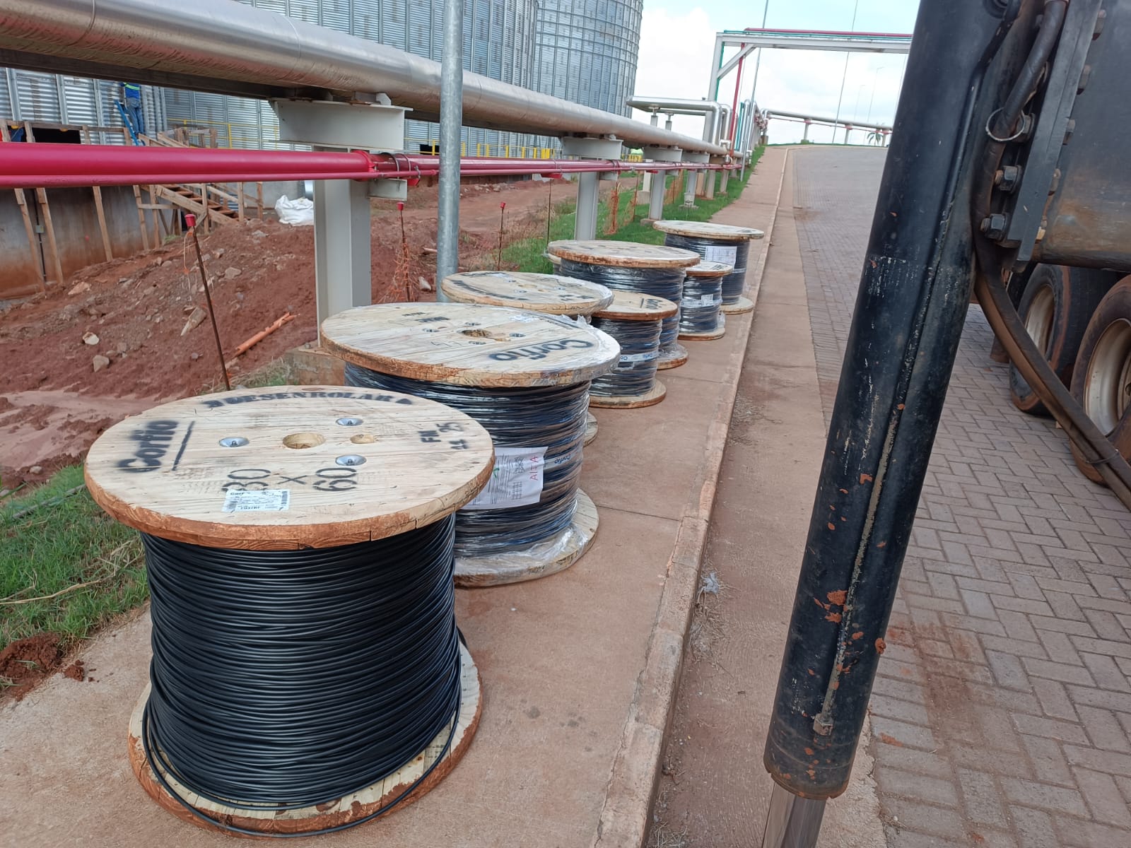 Bobinas de cabos elétricos Corfio em obra industrial com dutos e silos